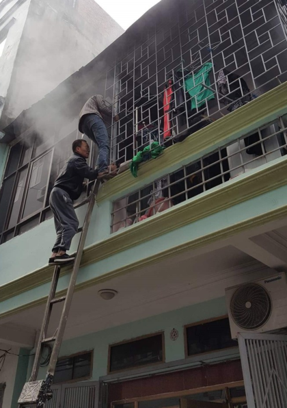 Người dân phố Cao Thắng, phường Yết Kiêu, Hà đông, bắc thang phá chuồng cọp ở căn nhà bị cháy. Ảnh: Kienthuc.net.vn.